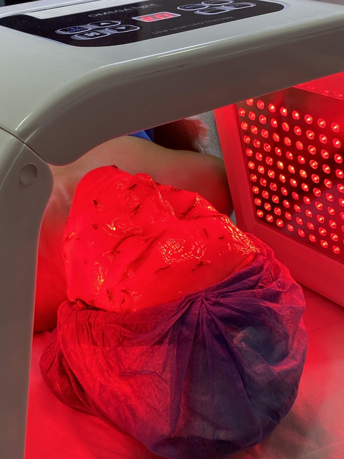 Panel de luz LED roja sobre el rostro de una clienta