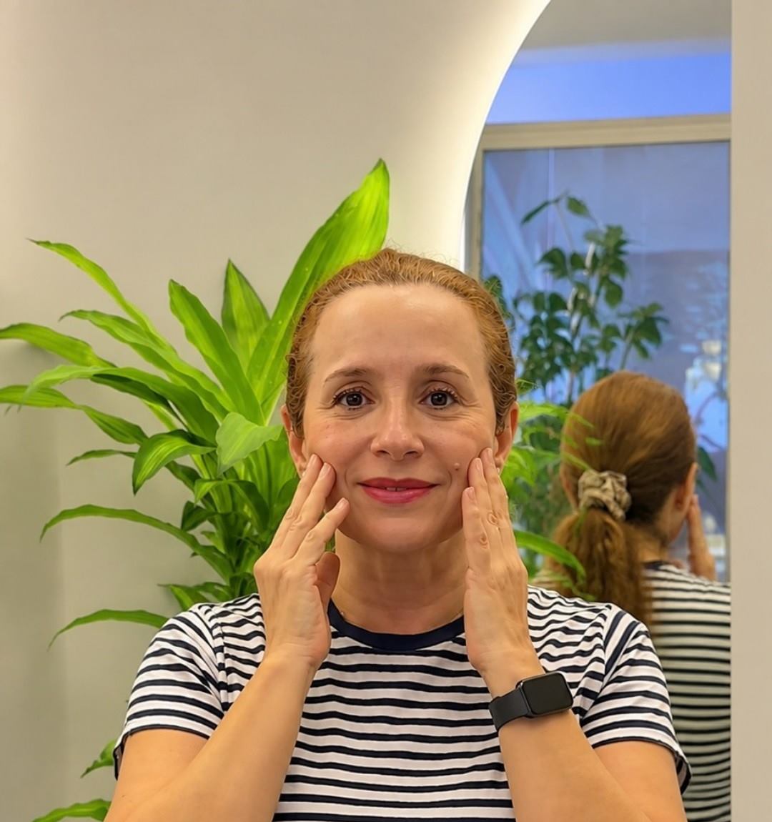 Luzme, clienta de Bcolor Spa, sonriendo con las manos en el rostro