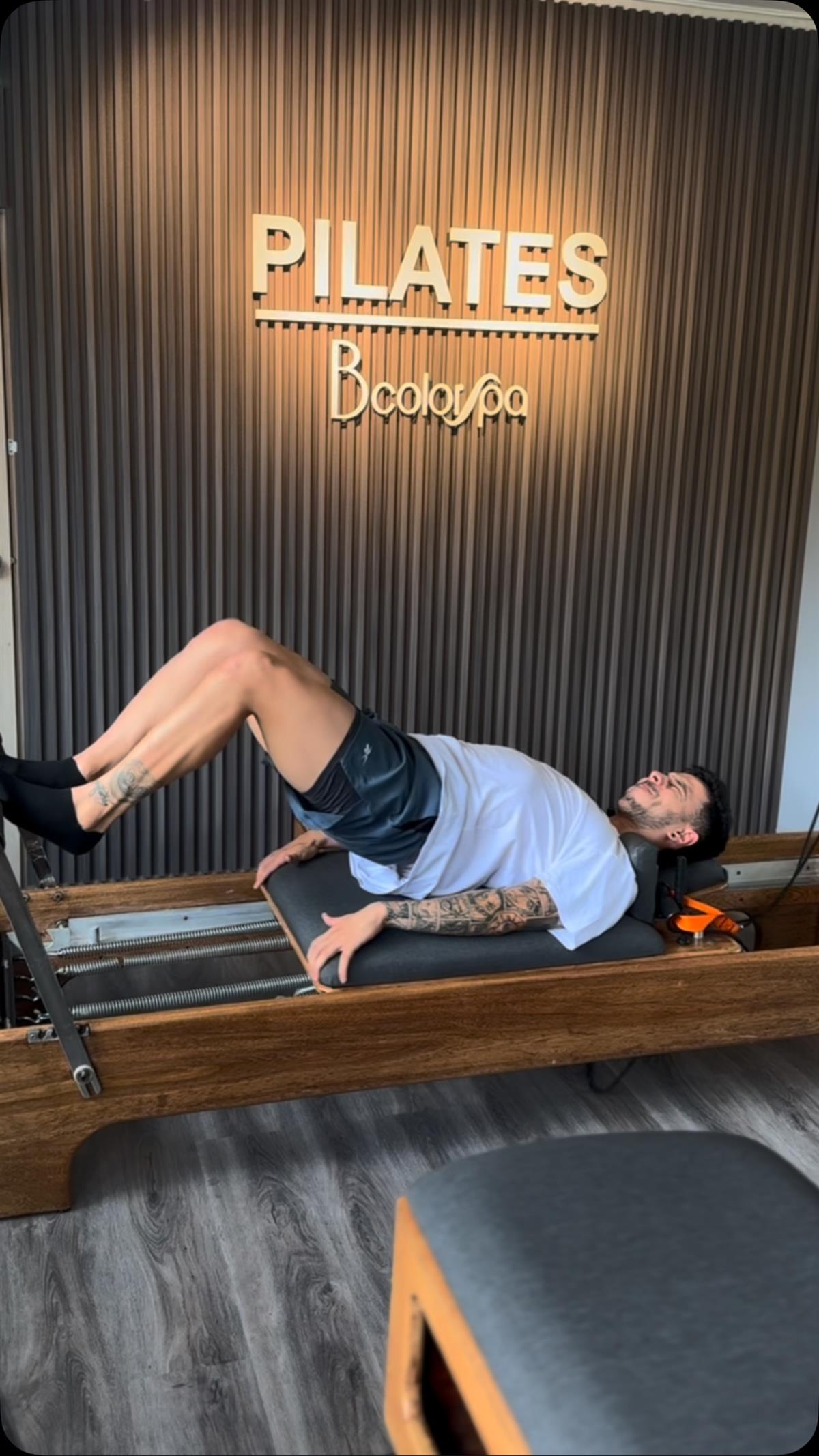 Alumno haciendo un puente sobre el reformer en la sala de pilates